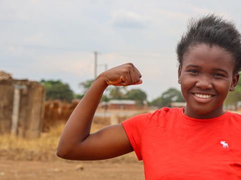 Young girl flexes her muscles