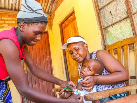 Lead Mother, Patience Mashava active screening Esther Ndaramo's child for malnutrition.