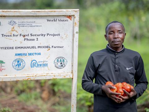 Emmanuel carrying tomatoes harvested from his firm.