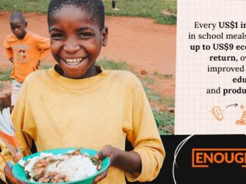 Child smiling holding a plate of food