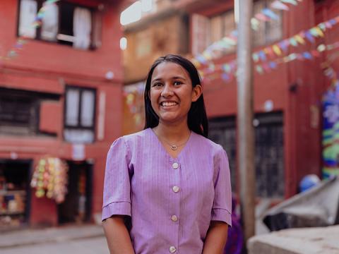 Prekshya gestures as she stands in the middle of a junction in her community.