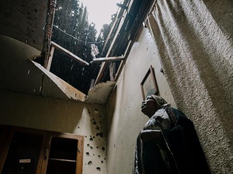 Woman stands in damaged home in Eastern DRC