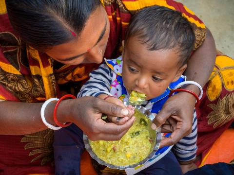 Mother feeding her young child a nutritious meal in Bangladesh