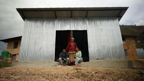 Mother and children in front of transitional shelter