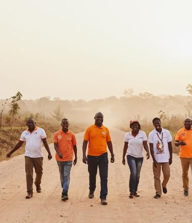 World Vision employees walk down a road in Ghana