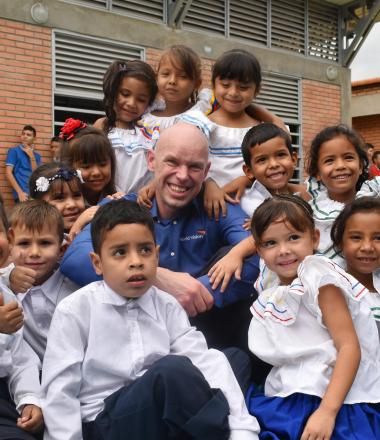 WVI President Andrew Morley sits with children in Colombia