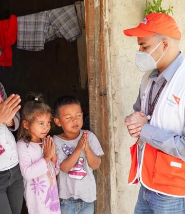 World Vision staff member prays with child in Ecuador