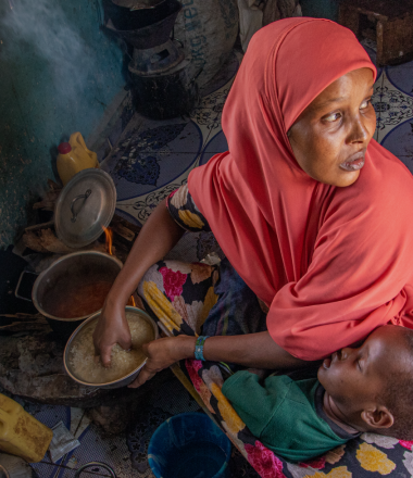 Mother cooking for malnourished child