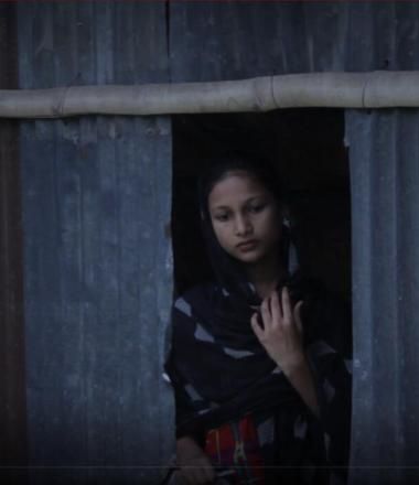 Girl stares out of window in house