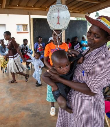 Gertrude CHW weighing baby