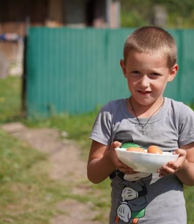 A child holding a plate with eggs