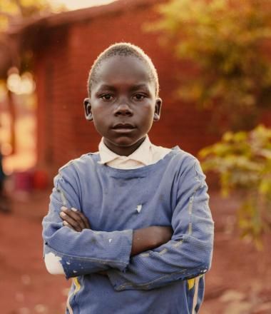 A child standing with crossed hands